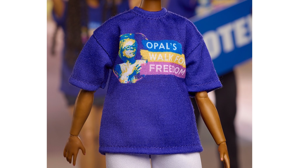 This barbie doll wears a Unity Unlimited Opal’s Walk for Freedom t-shirt. | Source: Mattel